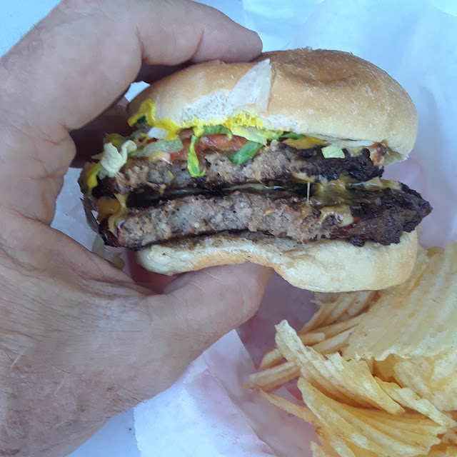 Double Cheeseburger in a Huge Hand