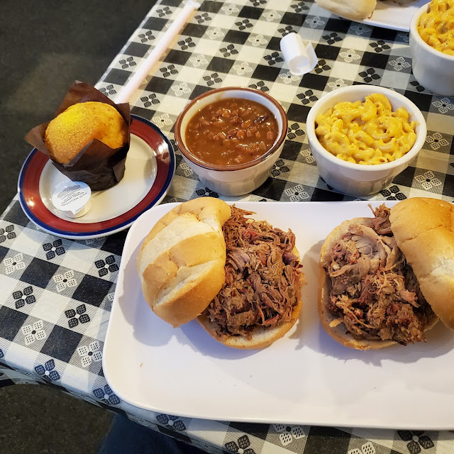 Pulled Pork Sandwich Smoky Beans Mac and Cheese and a Cornbread Muffin